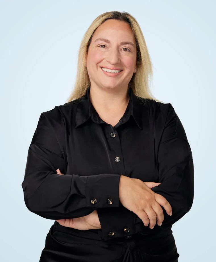 Holly Elabed headshot against light blue background